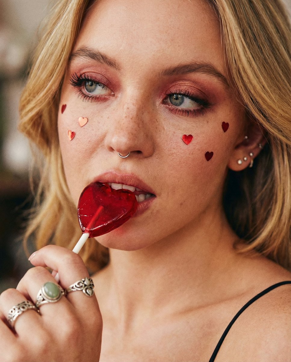 咬着心形棒棒糖的红晕少女