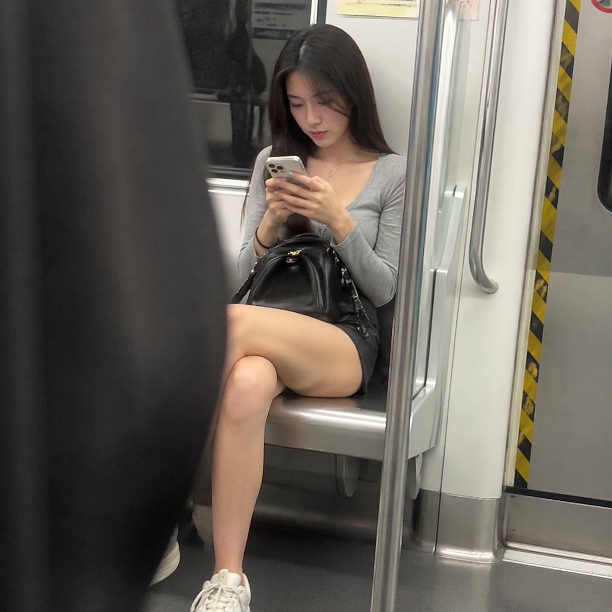地铁上看手机的女人