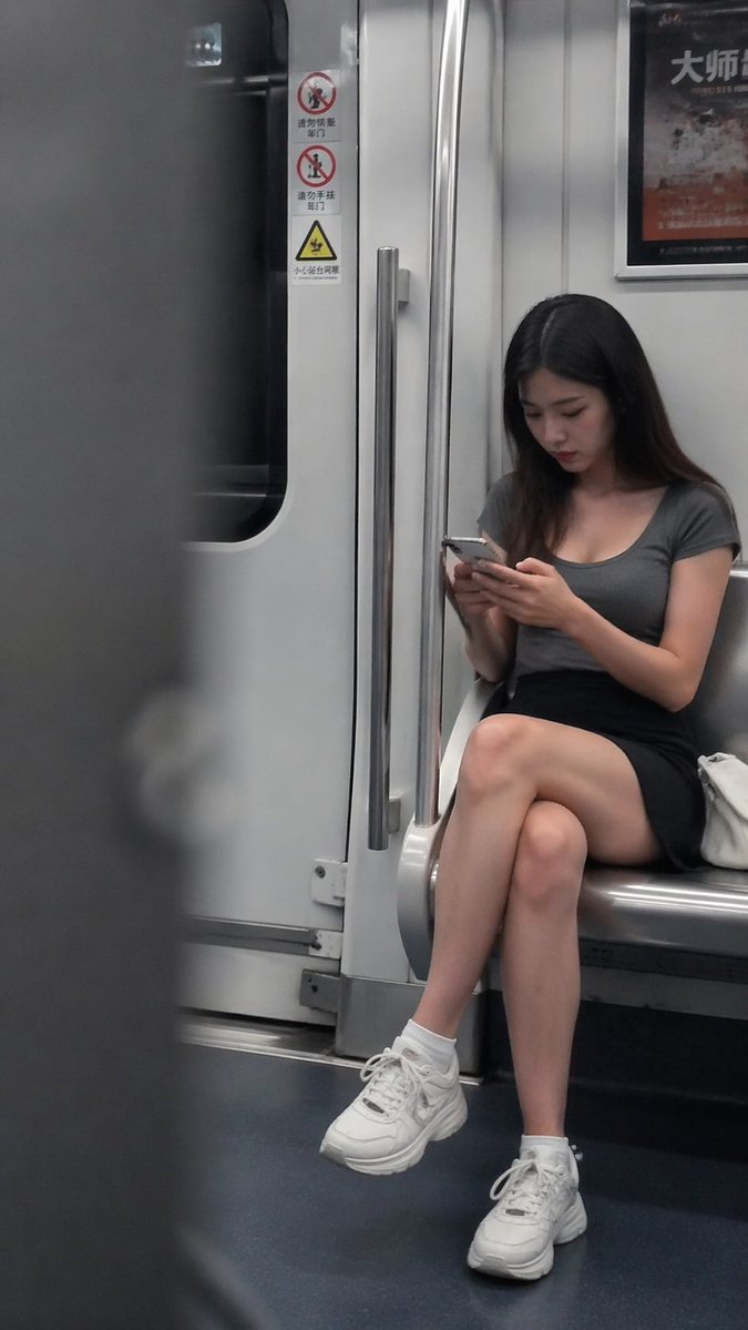 地铁抓拍：低头看手机的年轻女性