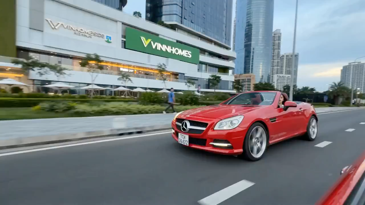 驾驶红色敞篷跑车在胡志明市江边说唱